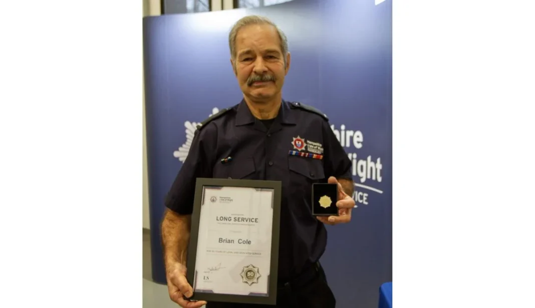 Brian Cole holding long service certificate